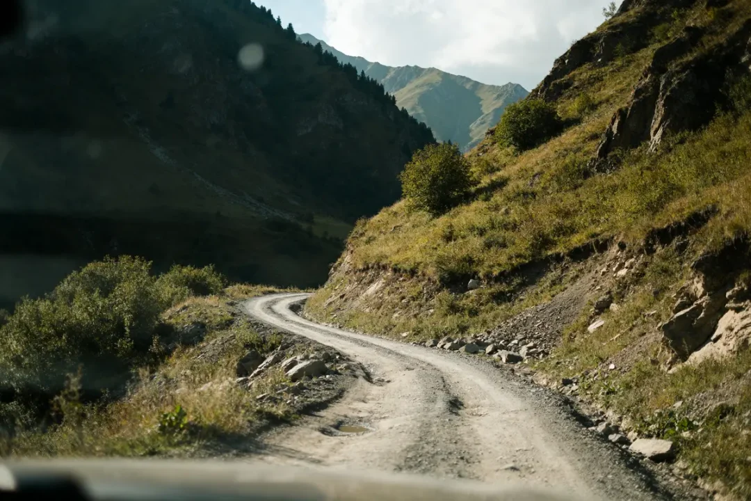 Route montagneuse sinueuse et dangereuse en Géorgie pays dangereux entre collines verdoyantes et rochers