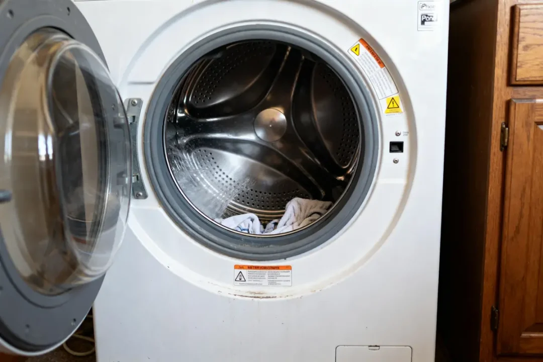 Machine à laver avec bruit de marteau-piqueur ouverte avec linge à l'intérieur