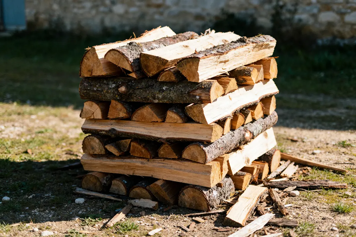 Stère de bois empilés sur le sol en extérieur pour calculer le prix