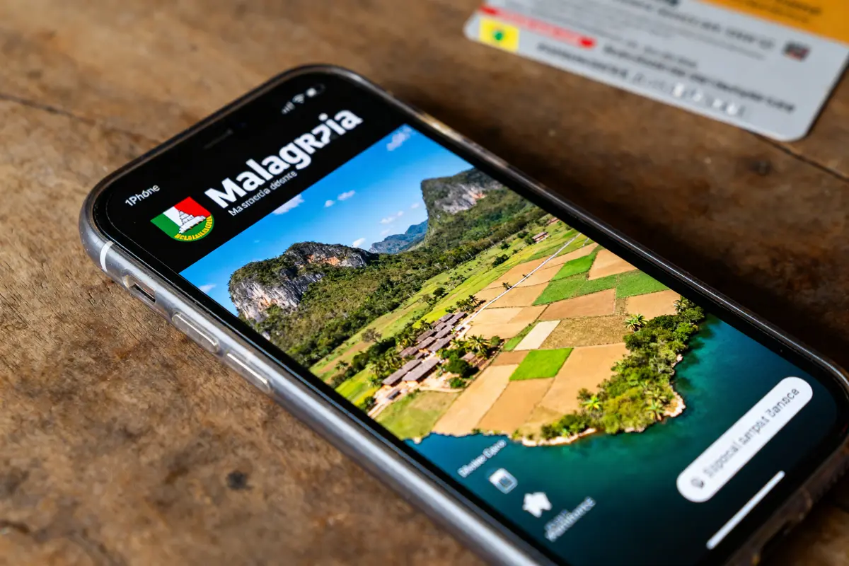 Téléphone affichant paysage rural illustrant la superficie de Madagascar avec des champs et collines