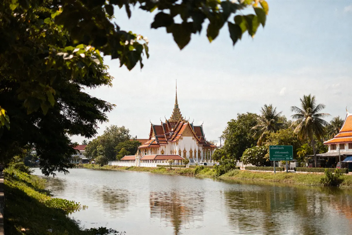 Temple thaïlandais traditionnel au bord d'une rivière soulignant le decalage horaire en Thailande