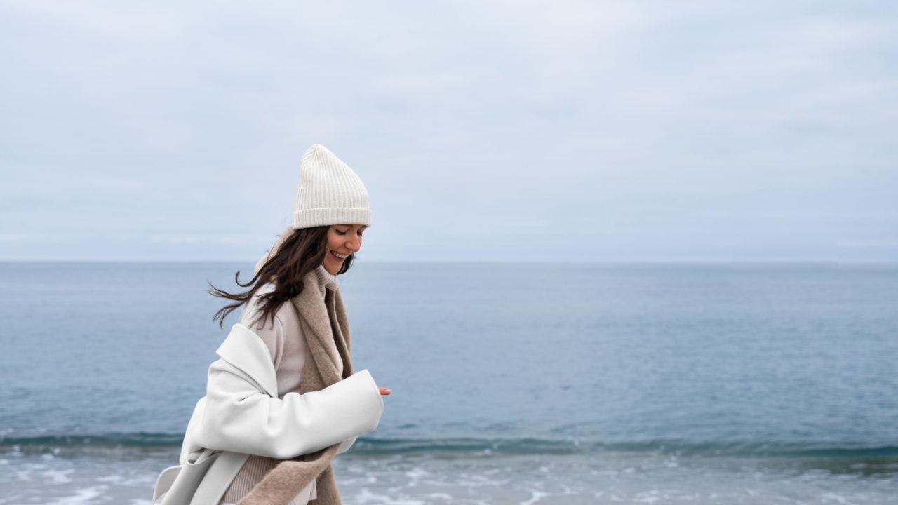 Vue latérale smiley femme marchant sur la plage